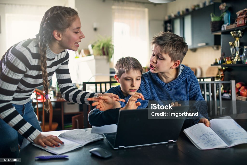 Three kids fighting for laptop at home The school has been closed during coronavirus outbreak and the classes have moved to e-learning platform. 
Three kids are fighting for a single laptop to do the homework.
Nikon D850 Arguing Stock Photo