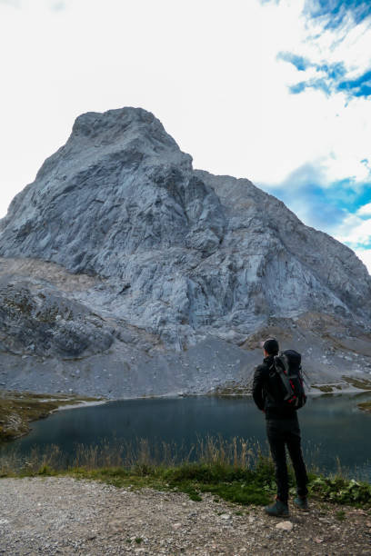 istock High Wait - A man posing by the Alpine lake 1214702263
