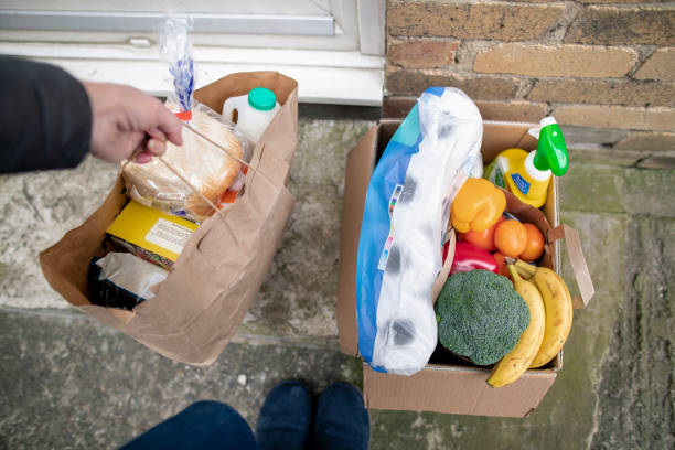 Home Delivery to Doorstep A point of view shot of a woman dropping off a box of groceries to her daughter and grandsons house, she leaves the box on the doorstep to avoid contact with her family. home delivery photos stock pictures, royalty-free photos & images