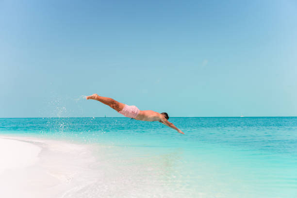 istock Young man plunging into the turquoise sea 1214702670