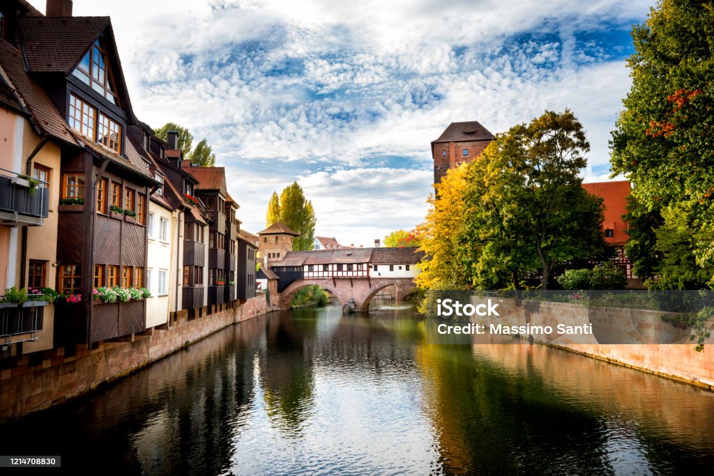 Nuremberg, Hangman's Bridge over the Pegnitz River. Franconia, Germany This beautiful wooden bridge is one of Nuremberg`s most fascinating historical sites. The picturesque building connects the Trödelmarkt island with the rest of Nuremberg from 1457. Its intimidating name was born in the Middle Ages: this is due to the fact that the executioner of the city lived in a nearby tower. Fuerth Stock Photo