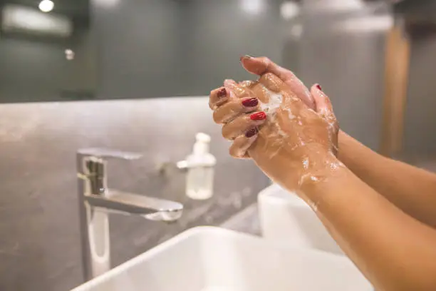 Photo of Business woman hand washing with soap to prevent Coronavirus