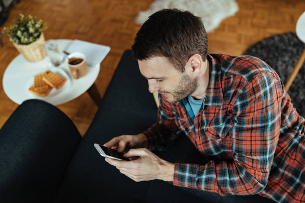 istock Young man typing text message on mobile phone at home. 1214712394