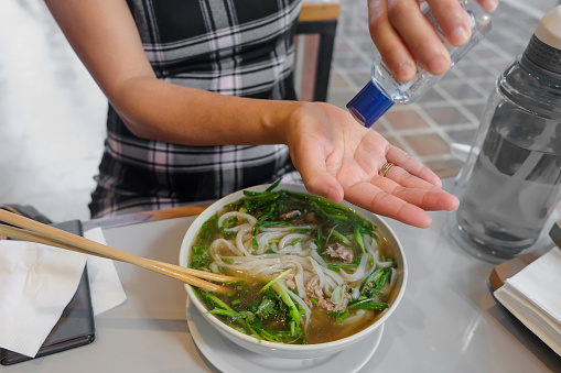 Close up shot of Chinese female hands applying hand sanitizer gel before eating food