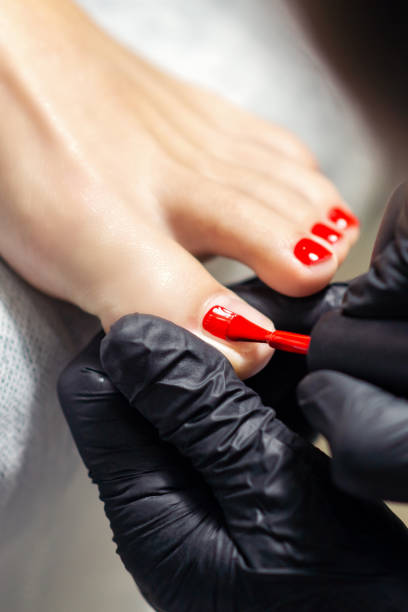istock Hands painting toenails in red. 1214712965