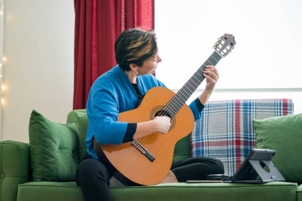 istock woman having online guitar lesson 1214713682