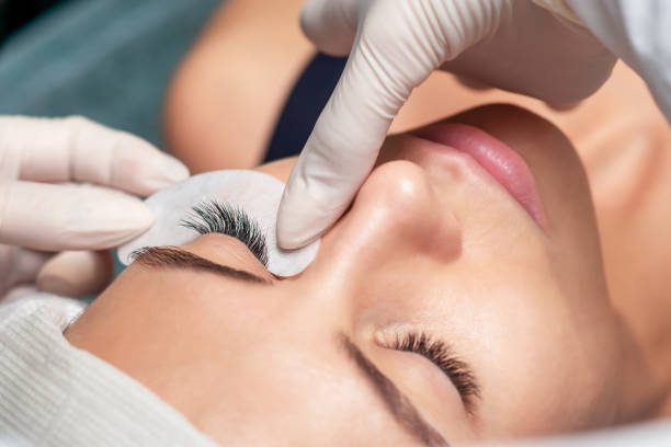 Eyelash extension procedure. Young woman receiving extending the eyelashes in a beauty salon, close up, eyelash extension procedure. false lashes stock pictures, royalty-free photos & images