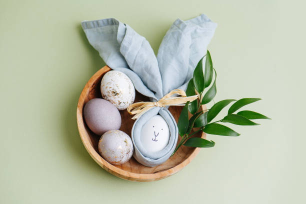 istock Easter egg in a napkin along with gilded eggs in a wooden bowl 1214715942