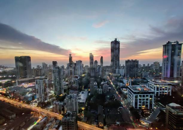 закат среди расползающихся небоскребов мумбаи - mumbai стоковые фото и изображения