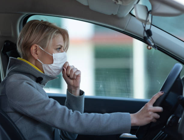 istock Woman wearing a face mask while driving a car 1214716262