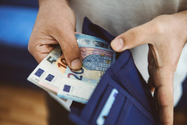 unrecognizable young man takes money out of his wallet stock photo
