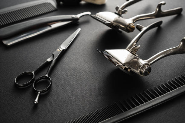 istock On a black surface are old barber tools. two vintage manual hair clipper, comb, razor, shaving brush, hairdressing scissors. black monochrome. 1214717699