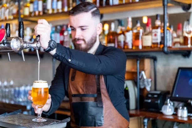 istock Bartender pouring beer into a glass 1214720074