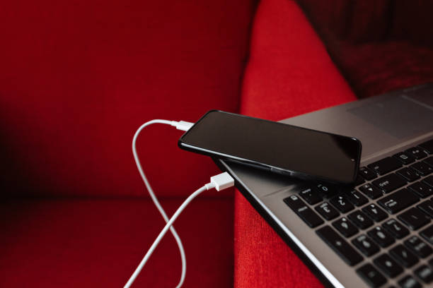 The smartphone is charging from the laptop