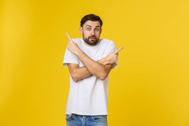 istock Handsome man over isolated yellow wall frustrated and pointing to the front. 1214726371