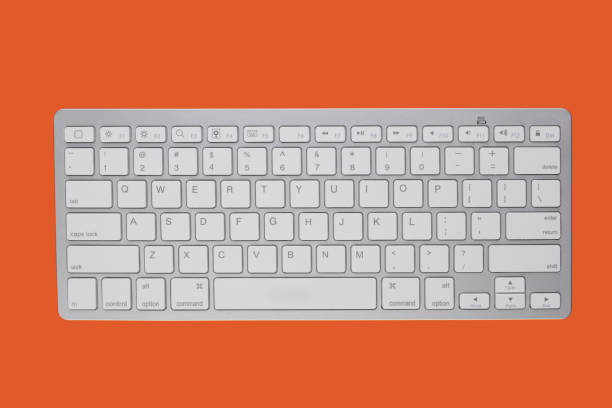 istock Wireless keyboard on an orange background. View from above. 1214727143