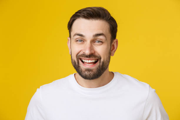 istock Young man looking at copyspace having a surprised or satisfied look isolated on yellow background. 1214728971