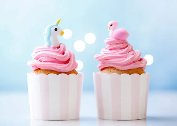 Homemade cheerful party cupcakes with flamingo and unicorn.