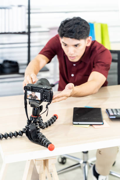 Vlogger blogger set up live camera Young asian male blogger setting up camera for recording live vlog video tutorial session at home. IT blogging or vlogging, social media hobby broadcasting, or online learning course concept. home recording studio setup stock pictures, royalty-free photos & images
