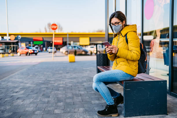 istock Woman in shopping mall with face mask using phone 1214731023