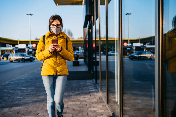 istock Woman in shopping mall with face mask using phone 1214731148