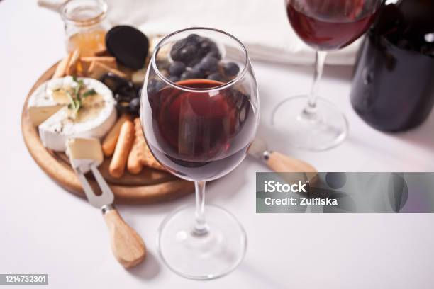 赤ワイン2杯とプレートチーズフルーツその他のスナックを合わせパーティーに - 赤ワインのストックフォトや画像を多数ご用意 - 赤ワイン, チーズ, ワイン