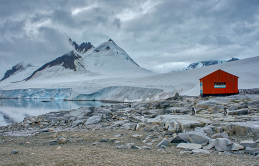 Antarctica Peninsula, Antarctica - February 10, 2020: Research outpost huts along Damoy Point in the breathtaking and awe inspiring Antarctica Peninsula in the great Southern Ocean during the short summer season.