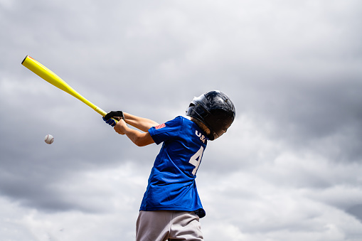 Baseball man, game face and hit ball with bat on a sport field in a game. Sports player with practice, strike and concentration to win match by competitive male batter focus during training outdoor