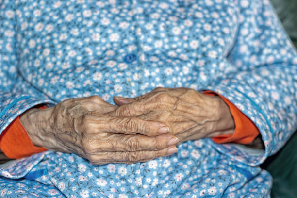 Front view of worried senior woman relaxing on sofa in living room at nursing home