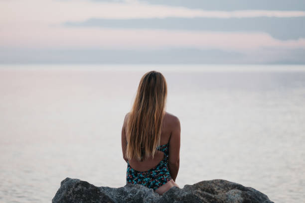 istock Young woman enjoying sunset on the beach 1214743147