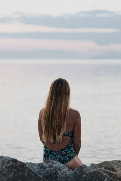 istock Young woman enjoying sunset on the beach 1214743677