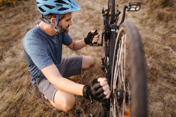 istock Mountain biker repairing broken bicycle 1214744172