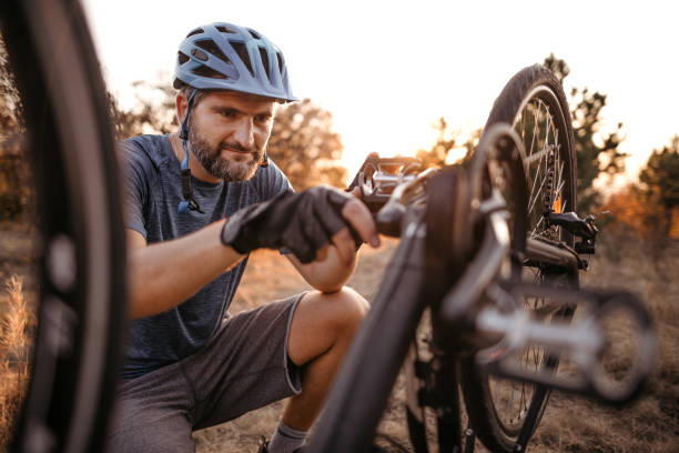istock Mountain biker repairing broken bicycle 1214744190
