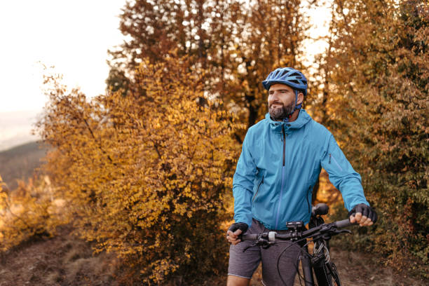 istock Mountain biker walking while holding bike 1214744208