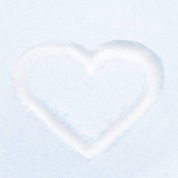 istock Blue heart shape drawing on white snow 1214746353