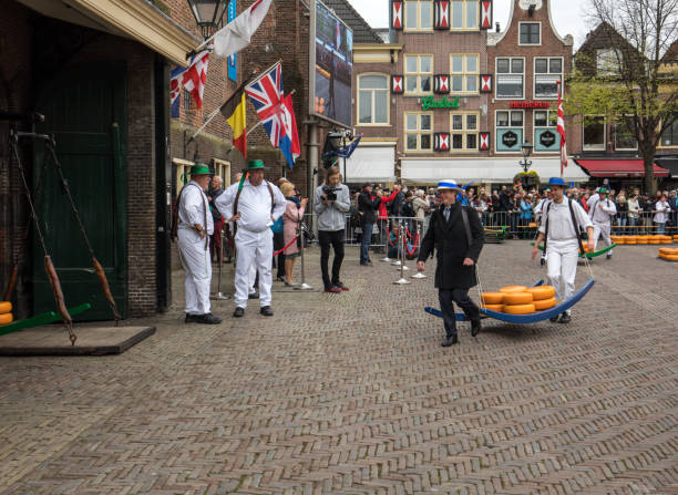 Carriers walking with many cheeses in the famous Dutch cheese market in Alkmaar Alkmaar, Netherlands - April 21, 2017: Carriers walking with many cheeses in the famous Dutch cheese market in Alkmaar, The Netherlands. The event happens in the Waagplein square. cheese dutch culture cheese making people stock pictures, royalty-free photos & images