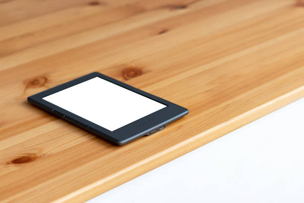 istock Gray electronic book or tablet with white blank mockup screen on a wooden table. Selective focus 1214750007