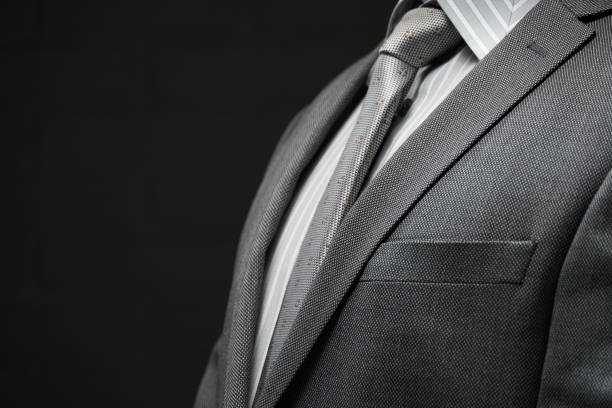 istock businessman portrait dressed in gray suit, dark wall background 1214750167