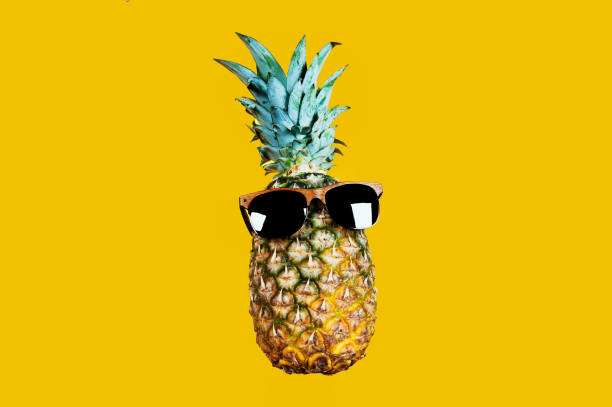 istock Pineapple with sunglasses isolated on yellow background. 1214750626