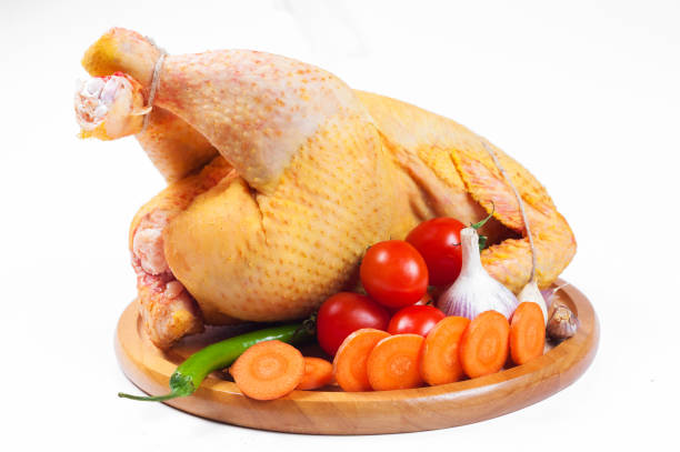istock Whole fresh Eco raw chicken with vegetables prepared for cooking on white background. 1214750647