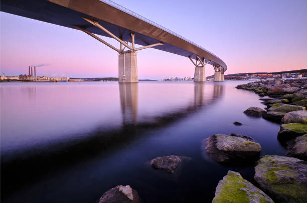 stor bro som går över en vik med stenar förgrund och en stad i bakgrunden - sundsvall bildbanksfoton och bilder