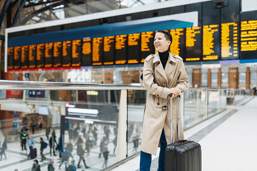 Young alternative looking woman with short hair and suitcase traveling to London