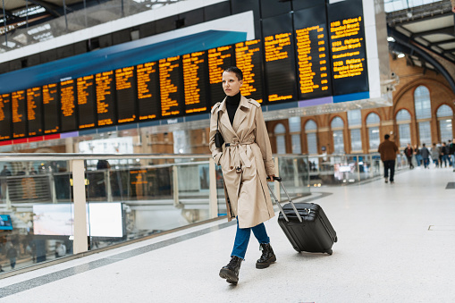 Young alternative looking woman with short hair and suitcase traveling to London