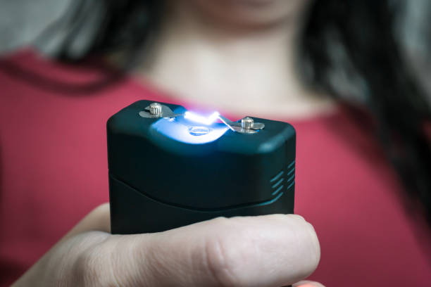 the stun gun in the hands is a close-up. selective focus - gun imagens e fotografias de stock