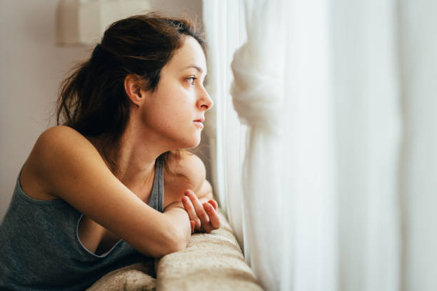 distanciation sociale pendant la pandémie de covid-19 - women depression window sadness photos et images de collection