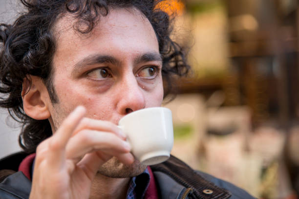 istock a smiling man drinking a coffee in a open air bar 1214754130