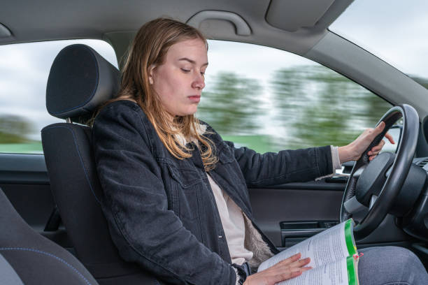 young woman is reading a book while driving a car - 11315 imagens e fotografias de stock