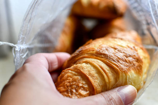 istock Woman grabbing a fresh croissant 1214757014