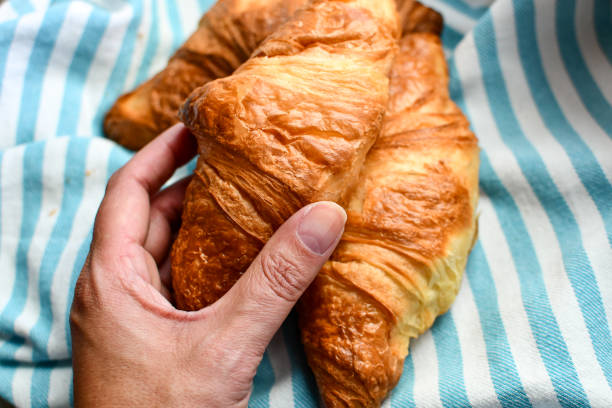 istock Woman grabbing a fresh croissant 1214757016