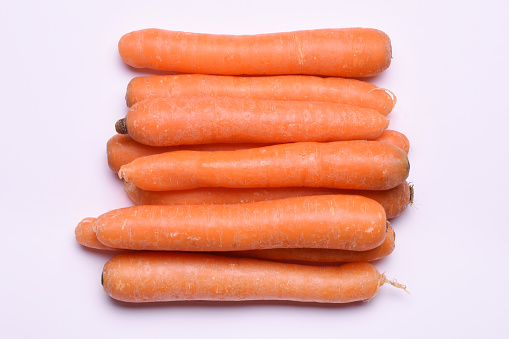 Directly above heap of carrots on white background